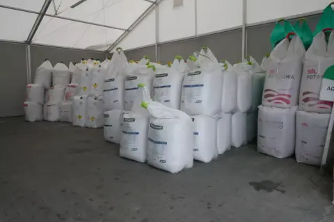 Duże worki z nawozami, w tym lubofoska pod zboża, czekają na rozładunek w magazynie.