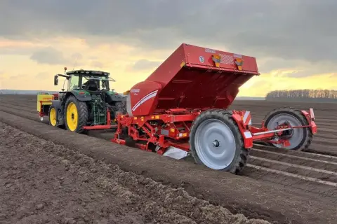 Traktor z sadzarką GRIMME sadzi ziemniaki. Optymalne ile kg sadzeniaków na 1 ha zależy od odmiany i warunków.