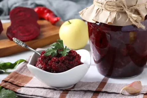 Słoik z przetworami z buraków, idealnych jako buraki pastewne dla kur. Obok miseczka z pastą buraczaną i świeże buraki.